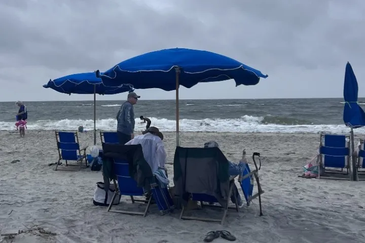 a blue umbrella sitting on top of a sandy beach