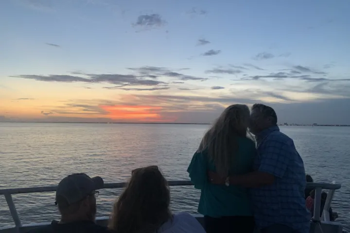 a man and a woman standing in front of a body of water